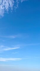 Clear Pale Blue Sky with Wispy Clouds Forming a Serene Atmospheric Background