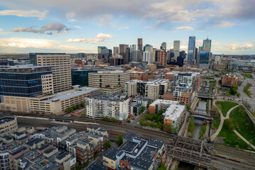 Aerial panoramic view of downtown Denver, Colorado, USA with modern skyscrapers, residential buildings, and green spaces along the river at sunset. Vibrant urban skyline and cityscape architecture.
