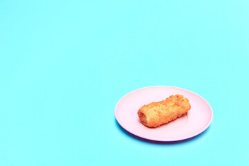Rissole or risoles on a pink plate with a blue background