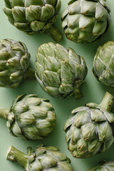 Obraz premium Artichokes on a Light Green Surface