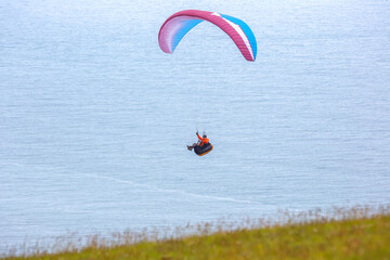 Paraglider soaring above the stunning coastline of Iceland during a serene day