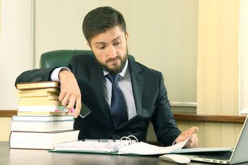 Businessman reviewing documents while managing tasks in a modern office environment