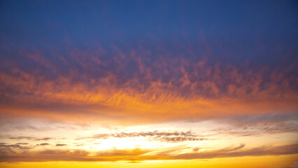 Vibrant sunset sky displaying a mix of colors over a serene landscape at dusk