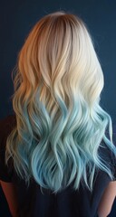 Naklejka premium Close-up of a woman from behind with shoulder-length blonde hair, half dyed in ombre green to white and the other half in long pastel blue waves