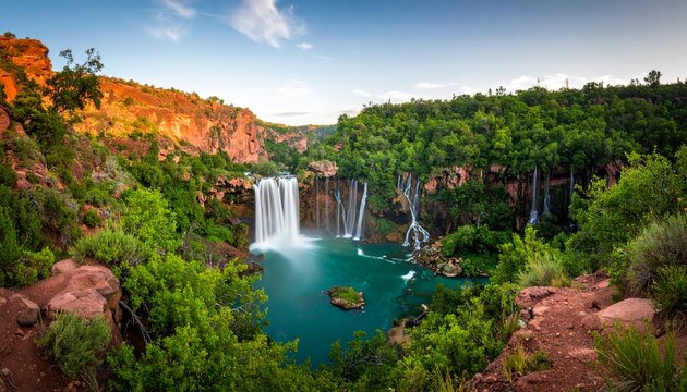 Cascading Waterfalls at Cascades dOuzoud Morocco surrounded by lush greenery and rocky cliffs under a blue sky.