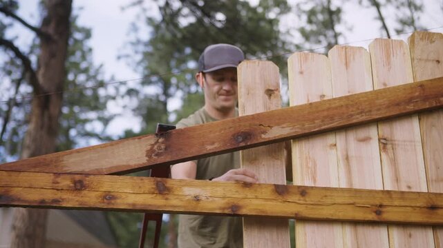 Home Improvement Scene of Man Installing Fence Board