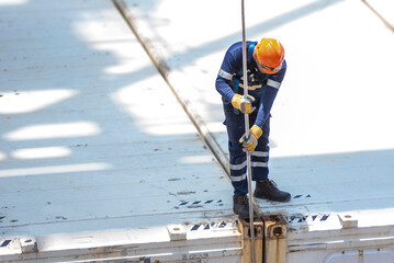 A port employee, stevedore, standing on deck of a container ship during his daily routine activities on board of merchant vessel. Balboa, Panama.