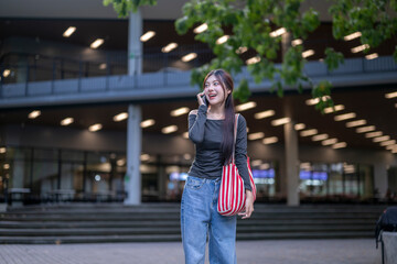 Fototapeta premium University student talking on phone while walking on campus