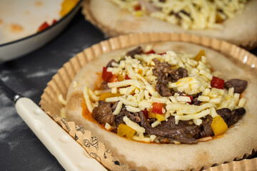 Delicious Beef Pizza Being Prepared with Fresh Ingredients and Melted Cheese