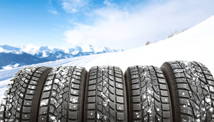 A couple of winter tyres for riding in the snow; mountain road background 