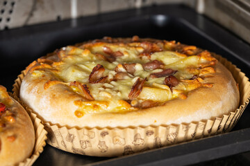Golden Crispy Bacon and Cheese Pizza Freshly Baked in a Paper Liner on a Tray