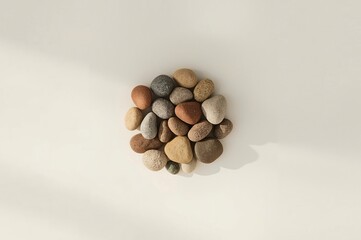 Smooth stones arranged in circle, sunlight, white background, zen