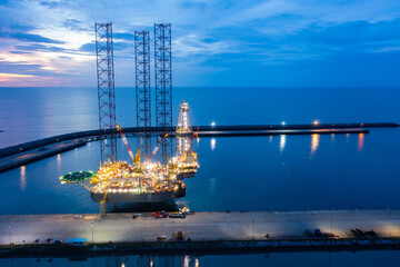 Aerial view of offshore jack up rig in a shipyard during sunset for oil and gas exploration and production.
