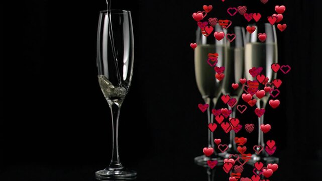 Bubbly stream filling left flute while red hearts floating around three glasses celebrating love