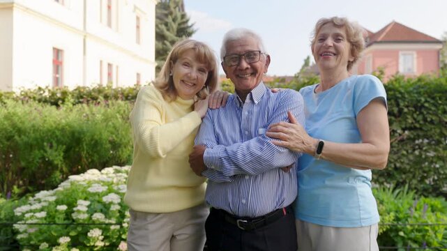 Heartwarming scene, three diverse seniors are joyfully enjoying their time together in a beautiful, vibrant garden, showcasing the love and deep connection they share with one another