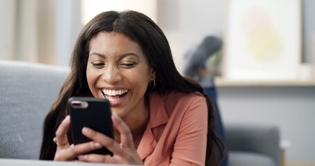 Fototapeta premium Happy woman, relax and laughing with phone on sofa for funny joke, social media or post in home. Female person, user or lying with smile on mobile smartphone for humor, comedy or connection in house