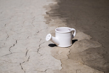 Ceramic watering can made from clay cracked by the heat in the desert