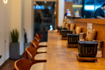 Counterbar seating inside the restaurant with gyukatsu grill tabletop. It is a small portable ceramic or volcanic stone grill.