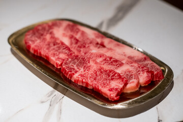 Raw Sliced Hanwoo Beef, marbled Korean Style Meat prepared on the golden plate