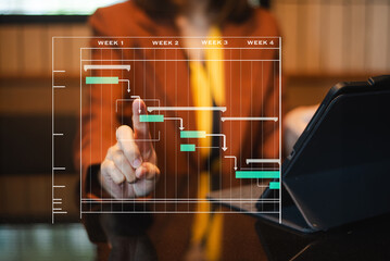 Hands typing on laptop with a digital Gantt chart overlay. Ideal for project planning, scheduling, productivity, workflow in office
