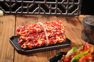 Air-Dried Salami Bundle Tied with Twine on Wooden Table - Traditional Cured Meat Delicatessen