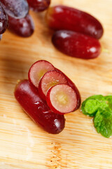 Fresh Red Grapes Sliced with Golden Seeds on Wooden Board - Healthy Fruit Photography