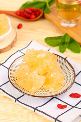 Handmade Yellow Rock Sugar Cubes with Herbal Tea and Goji Berries on Wooden Table