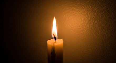 Illuminated candle casting a gentle glow in a darkened environment