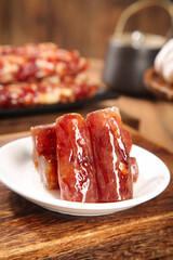 Sweet Glazed Air-Dried Meat Sausage Slices on White Plate - Traditional Cured Meat Delicacy