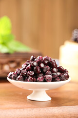 Purple Glutinous Corn Kernels on White Pedestal Bowl Wooden Table Yunnan Traditional Food Ingredient