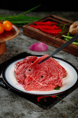 Fresh Raw Beef Slices on Plate with Vegetables Ready for Cooking and Meal Preparation