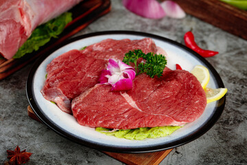 Fresh Raw Beef Steaks Set on Plate with Garnish and Vegetables on Wooden Cutting Board
