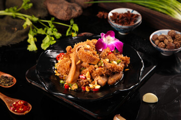 Spicy Braised Tripe Dish with Crispy Coating and Purple Orchid Garnish on Black Plate