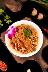 Fresh Spicy Tripe Dish with Chili Peppers and Herbs on Wooden Board - Traditional Asian Cuisine