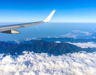 Aerial view of mountains, clouds, and city from airplane window