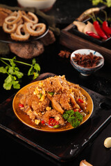 Spicy Tripe Dish Display - Traditional Asian Cuisine with Chili Peppers on Yellow Plate