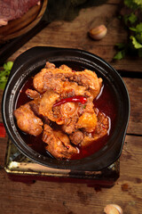 Spicy Oxtail Stew in Black Pot - Traditional Comfort Food on Rustic Wooden Table