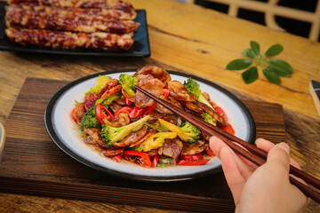 Asian Stir-Fry with Air-Dried Sausage, Broccoli and Sweet Peppers on Wooden Table