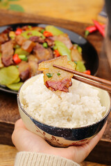 Asian Stir Fry with Bacon and Rice Bowl Held with Chopsticks