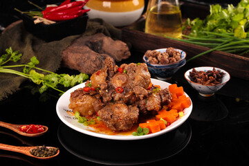 Spicy Braised Beef Tailbone Stew with Fresh Vegetables and Herbs on Rustic Wooden Table