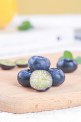 Fresh Alpine Blueberries from Yunnan on Wooden Board - Healthy Organic Berry Duo Cut in Half