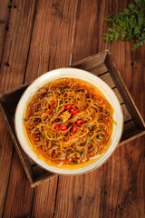 Sweet Potato Vermicelli Stir Fry with Minced Pork and Shredded Vegetables in Traditional Bowl on Wooden Table