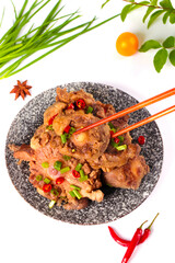 Braised beef tailbone with chilies and scallions in traditional Asian bowl with chopsticks