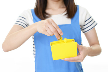 財布に小銭を入れるエプロン姿の女性