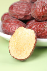 Red Xinjiang Jujube Dates in Bowl with Cut Half Showing Interior - Healthy Dried Fruit Snack