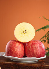Fresh Red Stripe Fuji Apples from Shandong China Sliced Half on Plate Orange Background