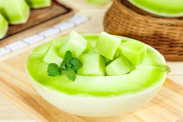 Fresh Honeydew Melon Slices with Mint in Bowl on Wooden Board - Healthy Summer Fruit Snack