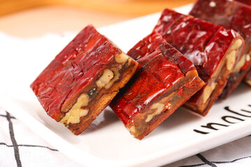 Xinjiang Red Date Jujube Pie Slices with Nuts - Traditional Chinese Dessert on White Plate