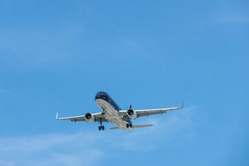澄み渡る夏空を降下する飛行機