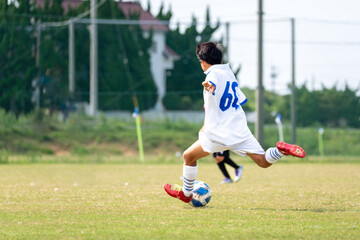 サッカーの試合をする中学生の男の子